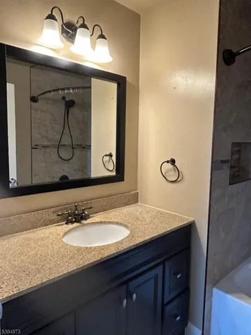 a bathroom with a sink vanity and mirror
