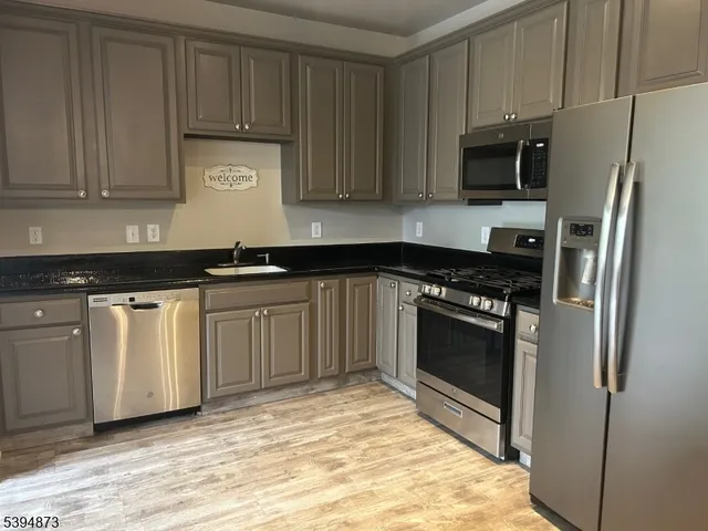 a kitchen with white cabinets sink and stainless steel appliances