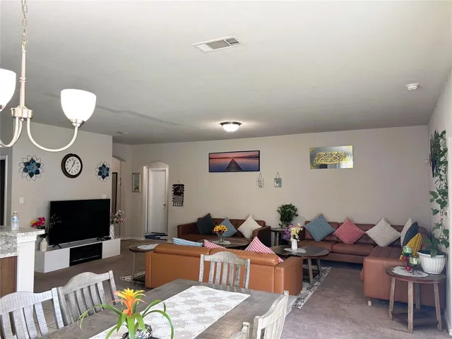 a living room with furniture a flat screen tv and kitchen view