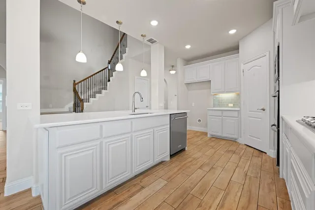a kitchen with cabinets and wooden floor
