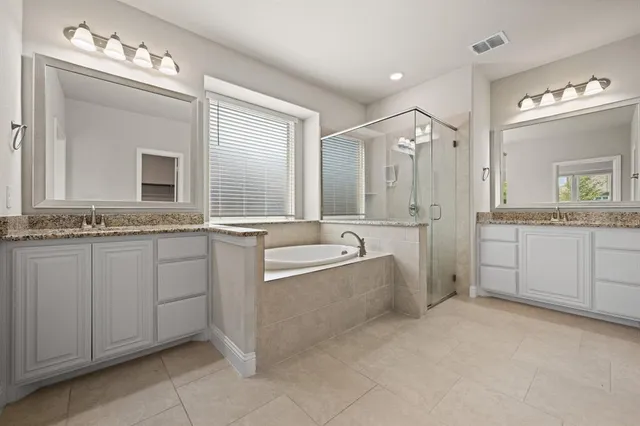 a bathroom with a granite countertop sink a mirror and a shower