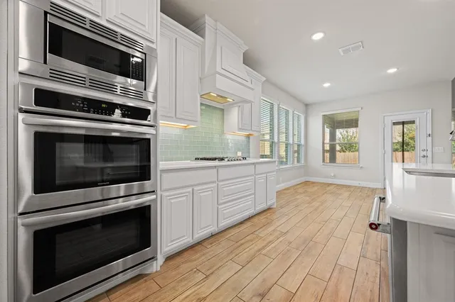 a view of empty room with wooden floor and cabinet