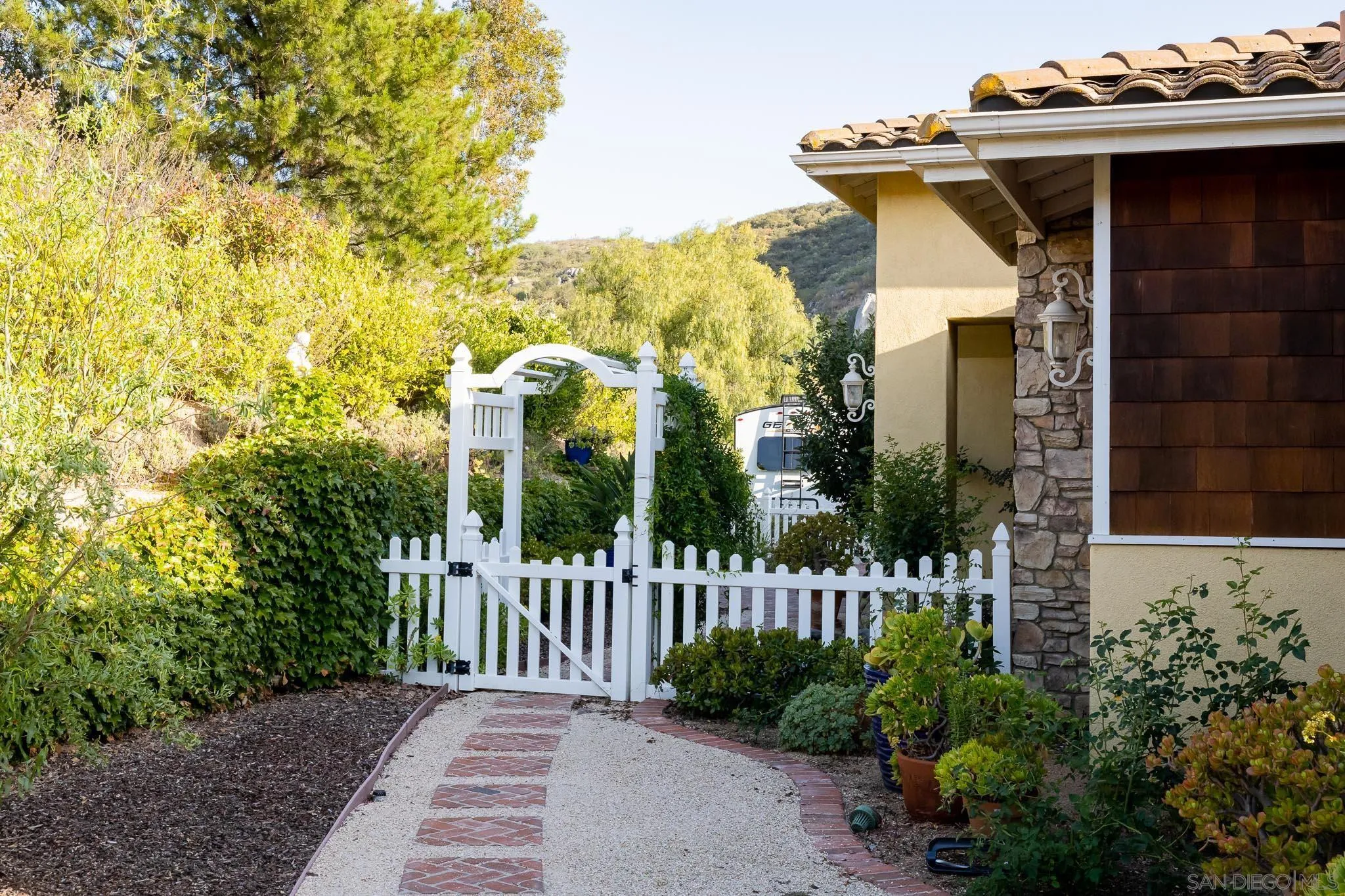 15435 Eastvale Road Poway, CA 92064 - Photo 42 of 57 a view of a house with a small yard and plants