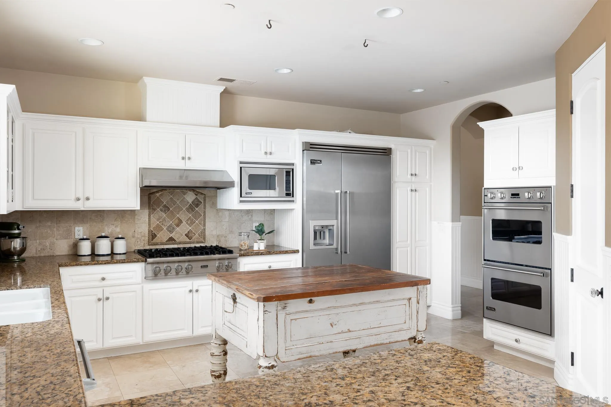 15435 Eastvale Road Poway, CA 92064 - Photo 6 of 57 a kitchen with kitchen island granite countertop a stove a sink and a refrigerator