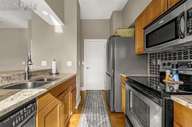 a kitchen with granite countertop a sink stove and refrigerator