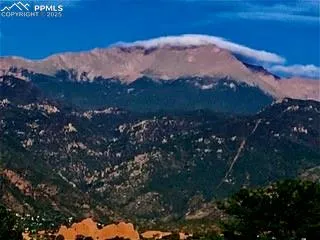 a view of mountain with sunset in background