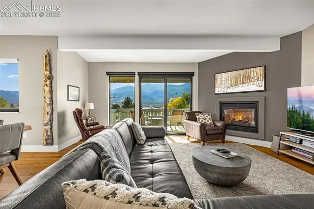 a living room with furniture a large window and a fireplace