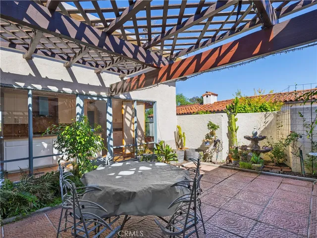 a view of a patio with table and chairs and potted plants
