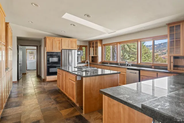 a kitchen with stainless steel appliances granite countertop a sink and a counter