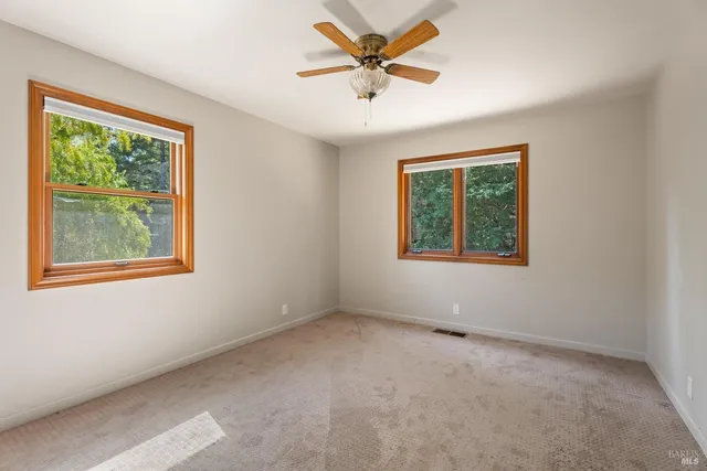 an empty room with a window and a fan