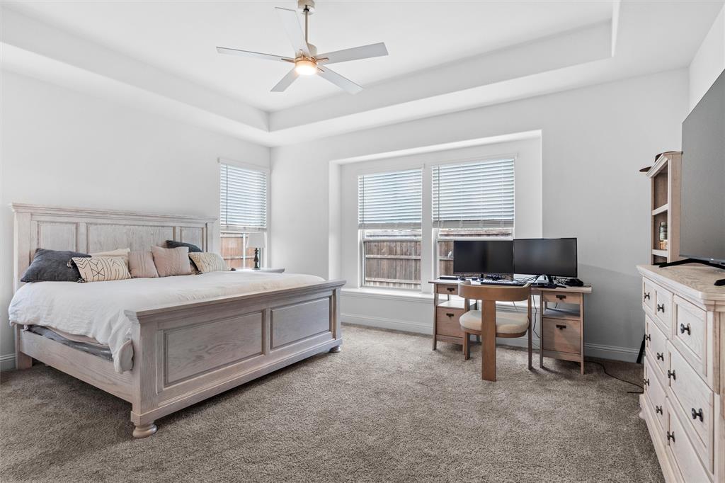 753 Truchas Avenue Forney, TX 75126 - Photo 13 of 29 a spacious bedroom with a bed and a flat screen tv