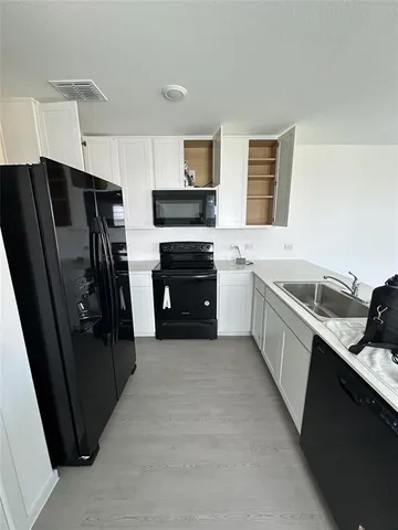 a large kitchen with a refrigerator a stove a sink and a dishwasher