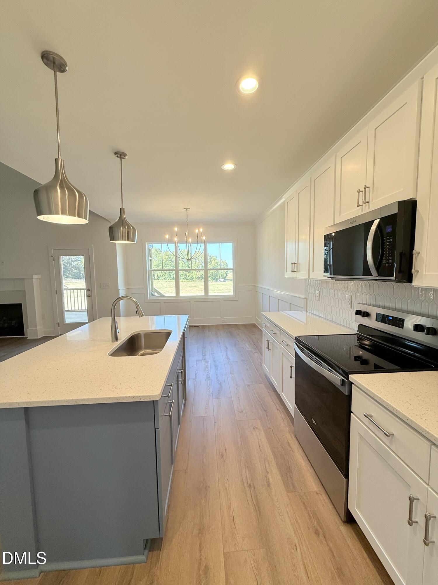 6906 Fire Tower Road Spring Hope, NC 27882 - Photo 6 of 32 a kitchen with stainless steel appliances granite countertop a sink a stove and a wooden floors