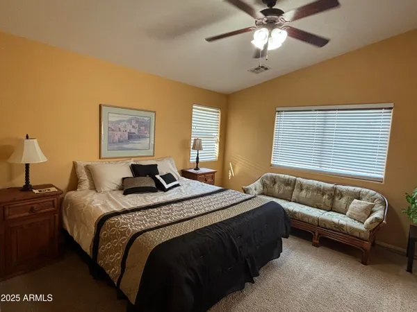 a bedroom with a bed couch and window