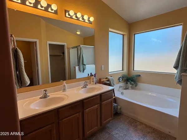 a bathroom with a bathtub double vanity sink and mirror