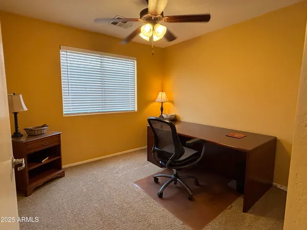 a view of a workspace with furniture and a window