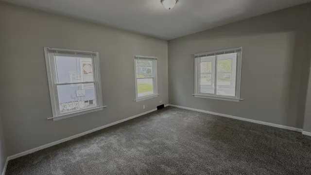 an empty room with windows and closet