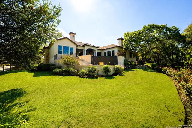 a front view of a house with a garden and trees