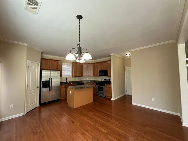 a view of a kitchen with a sink a refrigerator and wooden floor