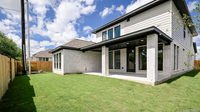 a view of a white house with a big yard and large tree