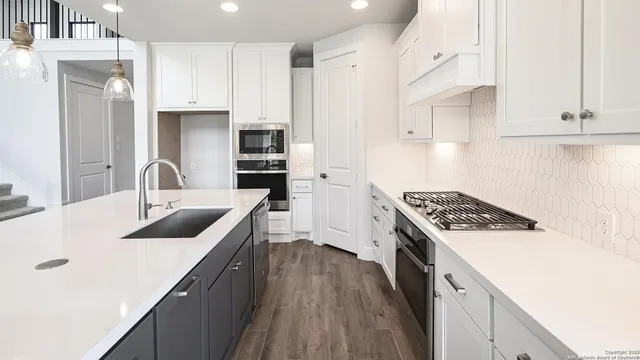 a kitchen with stainless steel appliances granite countertop a sink stove and refrigerator