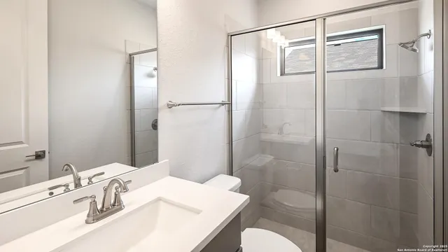 a bathroom with a sink a toilet and shower