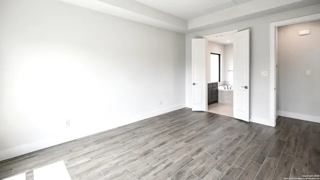 a view of empty room with wooden floor