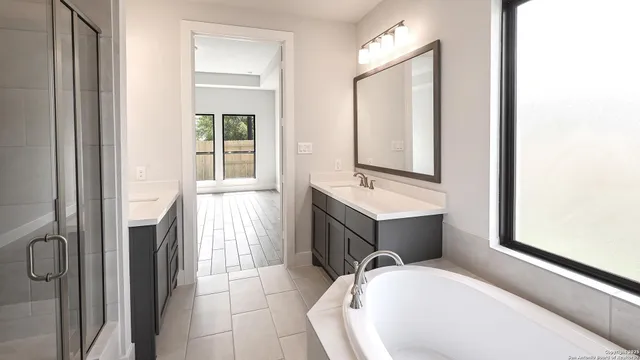 a bathroom with a tub sink and mirror