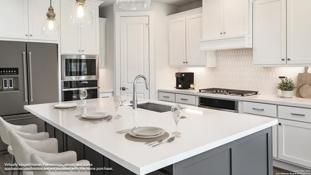 a kitchen with a sink a stove and white cabinets