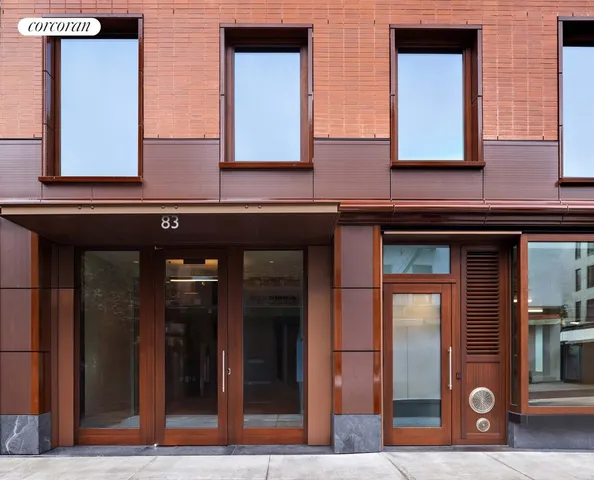 a front view of a building with lot of cars and trees