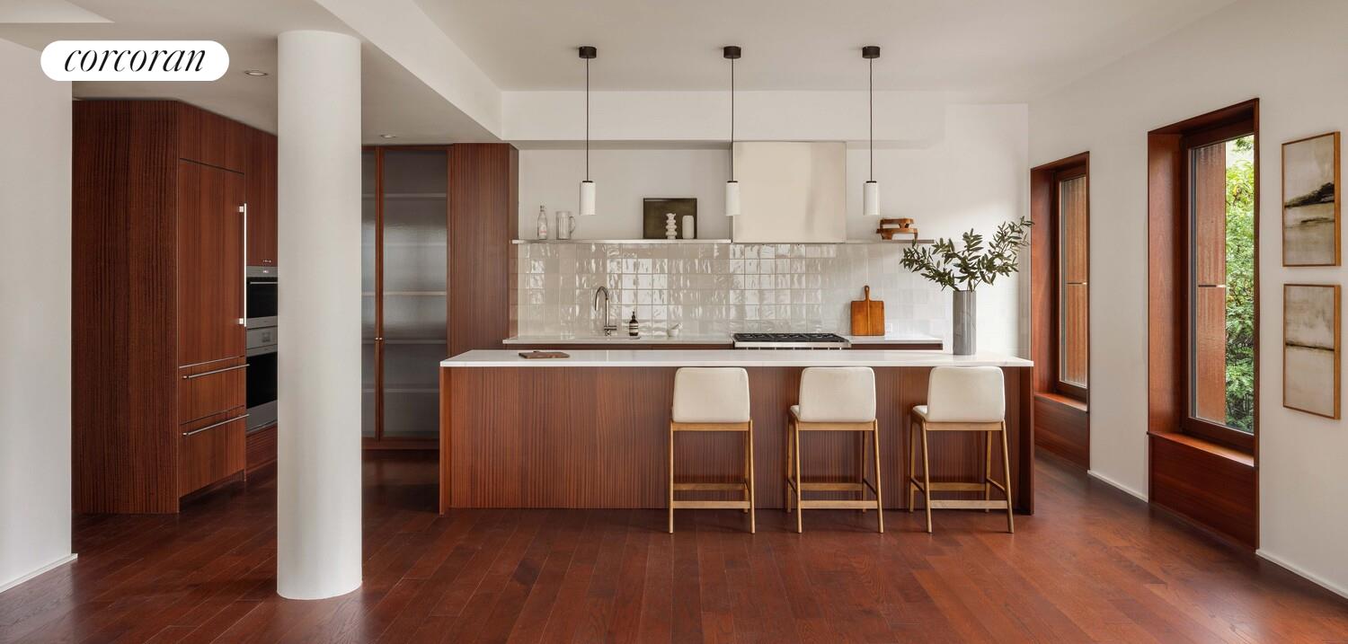 83 Thompson Street, Unit 4 Manhattan, NY 10012 - Photo 6 of 26 a kitchen with kitchen island granite countertop a refrigerator and a stove top oven