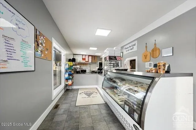 a view of kitchen with stainless steel appliances granite countertop lots of counter top space and wooden floor