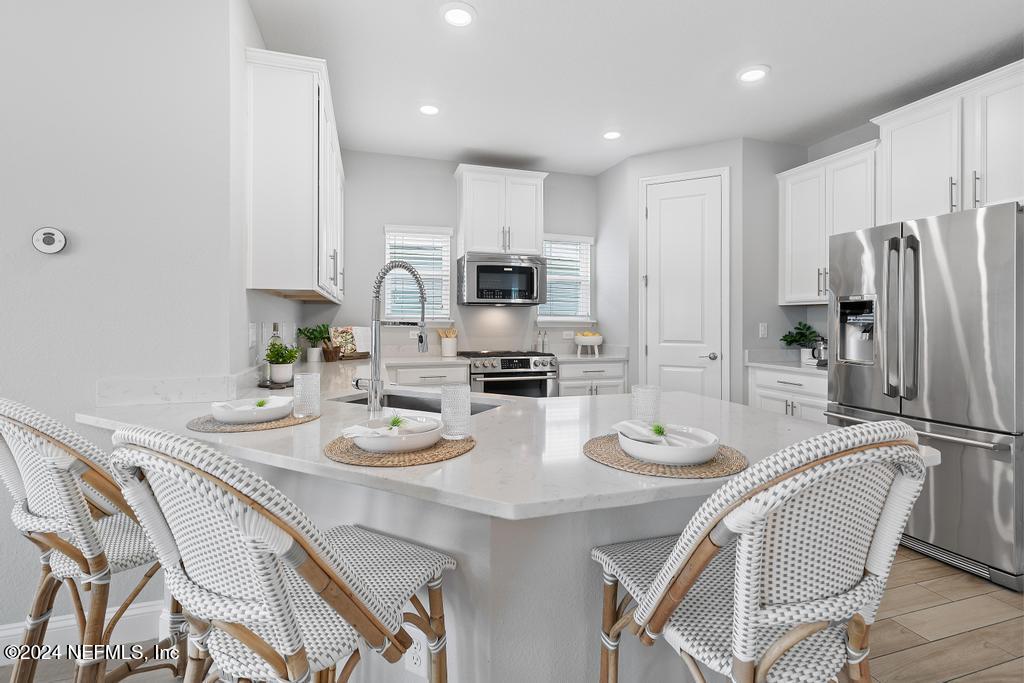 185 Clifton Bay Loop St. Johns, FL 32259 - Photo 12 of 92 a kitchen with stainless steel appliances granite countertop a dining table and chairs