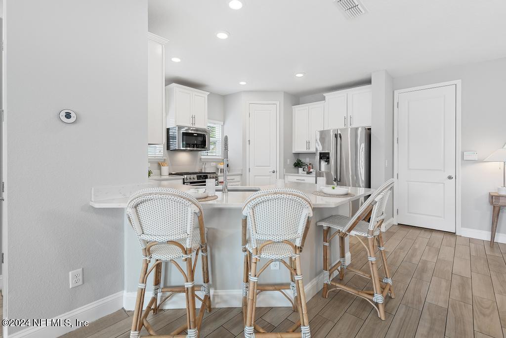 185 Clifton Bay Loop St. Johns, FL 32259 - Photo 13 of 92 a kitchen with stainless steel appliances a dining table and chairs