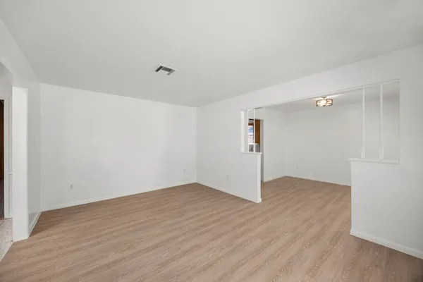a view of an empty room with wooden floor