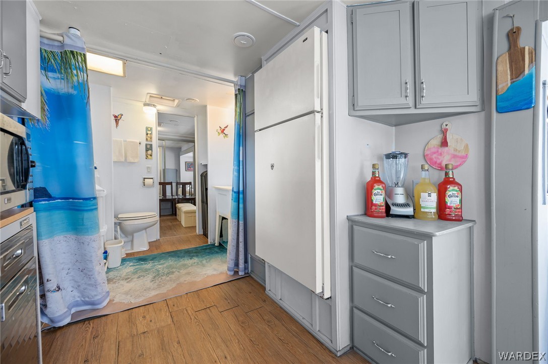 2000 Ramar Road, Unit 249 Bullhead City, AZ 86442 - Photo 10 of 40 Kitchen layout with cabinet storage, refrigerator space, and nearby bathroom access ? ready for your vision and updates.