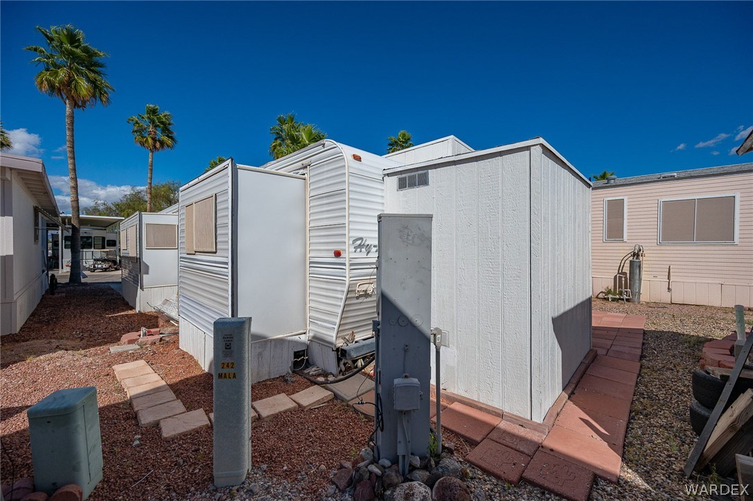 2000 Ramar Road, Unit 249 Bullhead City, AZ 86442 - Photo 17 of 40 Low-maintenance lot with storage structure, paved walkway, and dedicated utility connections.