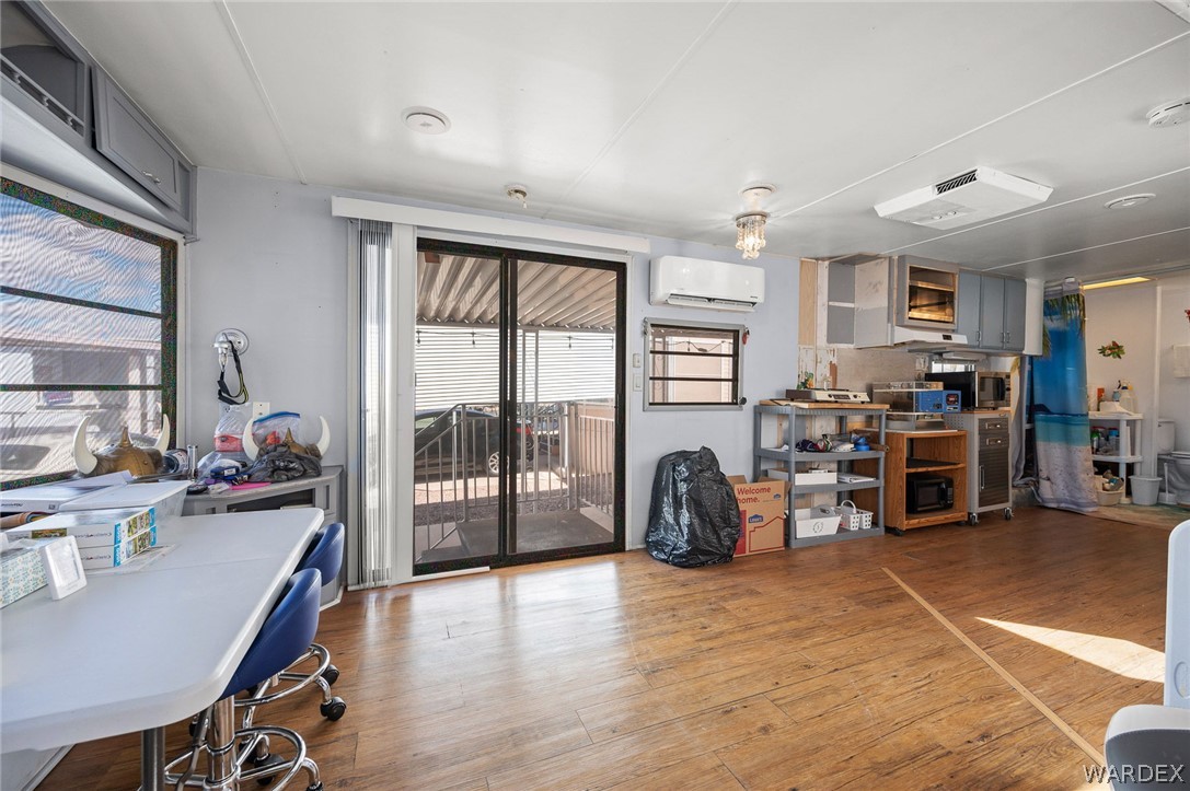 2000 Ramar Road, Unit 249 Bullhead City, AZ 86442 - Photo 6 of 40 Open-concept living space with wood-look flooring, sliding glass doors, and abundant natural light.