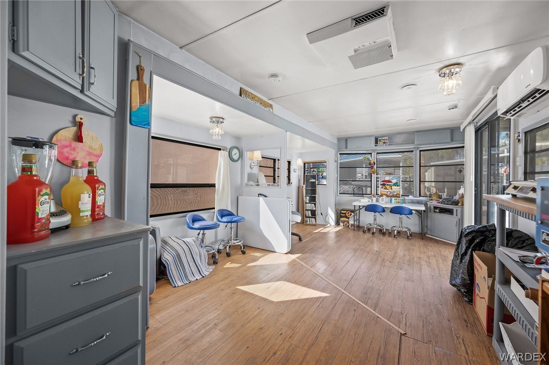 2000 Ramar Road, Unit 249 Bullhead City, AZ 86442 - Photo 9 of 40 Spacious open living area with wood-look flooring, abundant natural light, and energy-efficient mini split system.