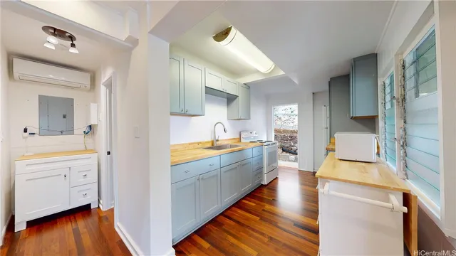 a large kitchen with a lot of counter space and wooden floor