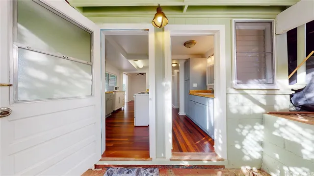 a view of a hallway with wooden floor and dining room view