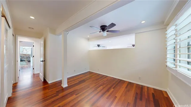 a view of empty room with wooden floor
