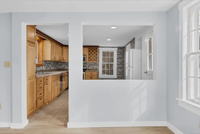 a view of a kitchen with a sink and dishwasher a refrigerator with white cabinets