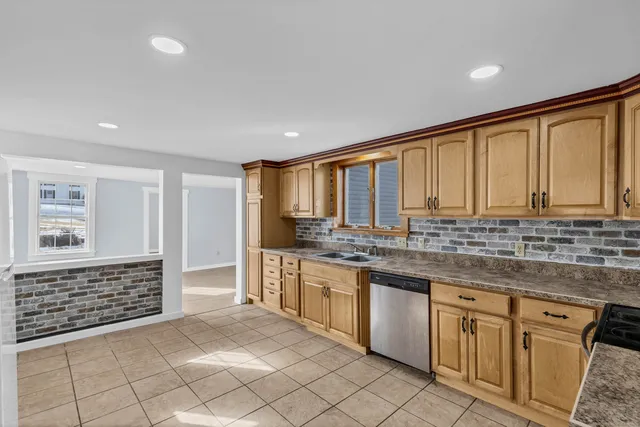 a kitchen with stainless steel appliances granite countertop a stove a sink and a refrigerator