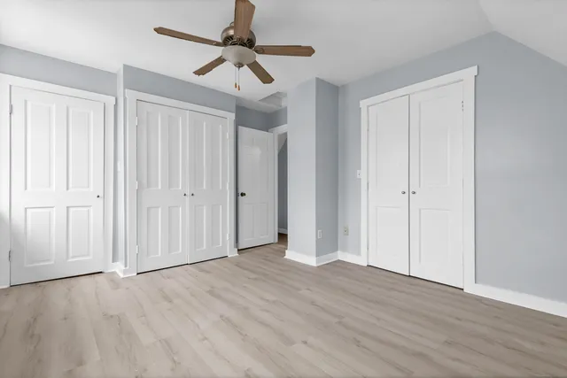 a view of an empty room with closet and wooden floor
