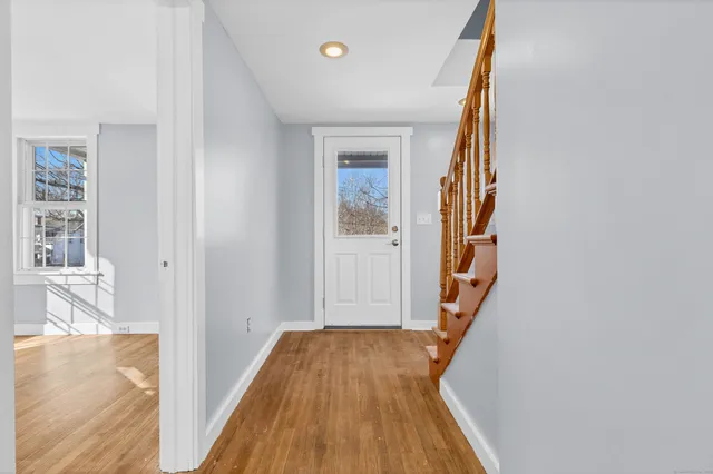 a view of a hallway with wooden floor and staircase