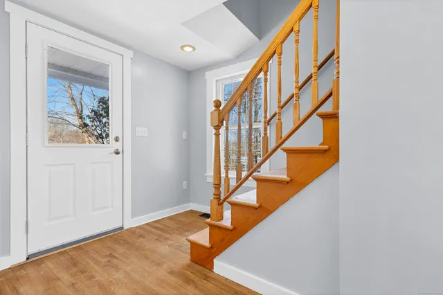 a view of entryway with wooden floor and stairs