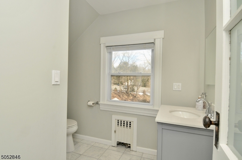 44 Dunnell Road Maplewood, NJ 07040 - Photo 17 of 18 a bathroom with a window a sink and a toilet