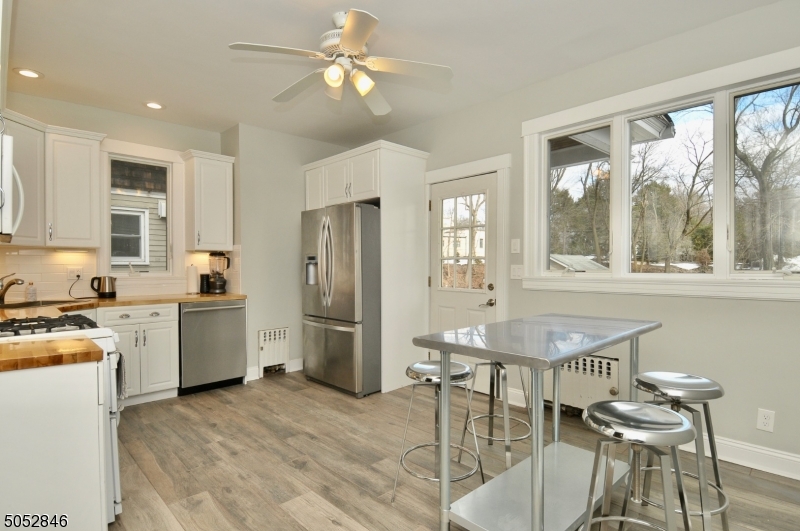 44 Dunnell Road Maplewood, NJ 07040 - Photo 6 of 18 a kitchen with a table chairs refrigerator and microwave