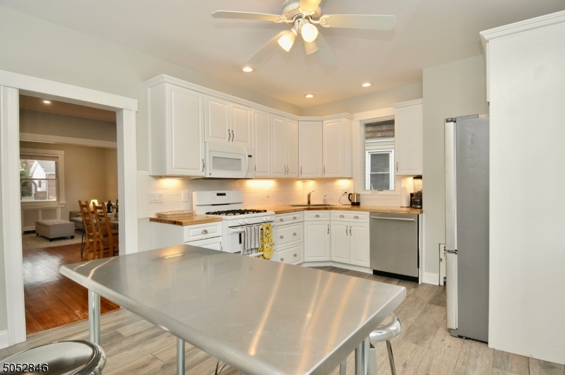 44 Dunnell Road Maplewood, NJ 07040 - Photo 7 of 18 a kitchen with a table chairs stove and cabinets